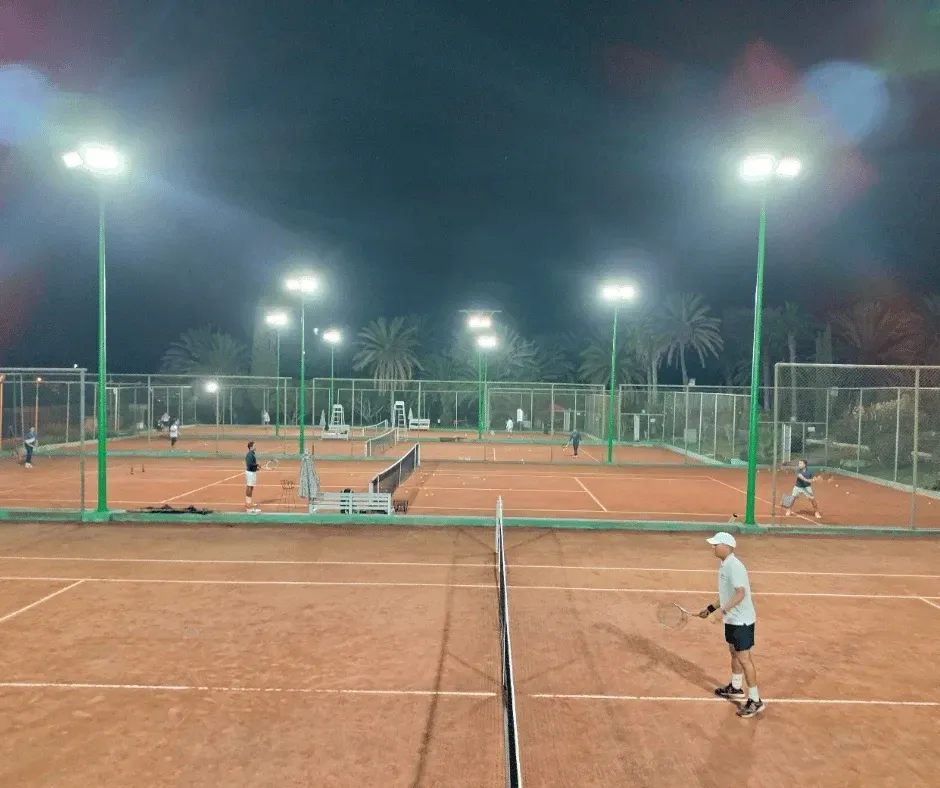 Jouer de nuit : les mêmes courts en soirée, éclairés par les projecteurs du club